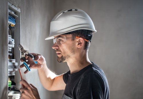 man-electrical-technician-working-switchboard-with-fuses-installation-connection-electrical-equipment (2)